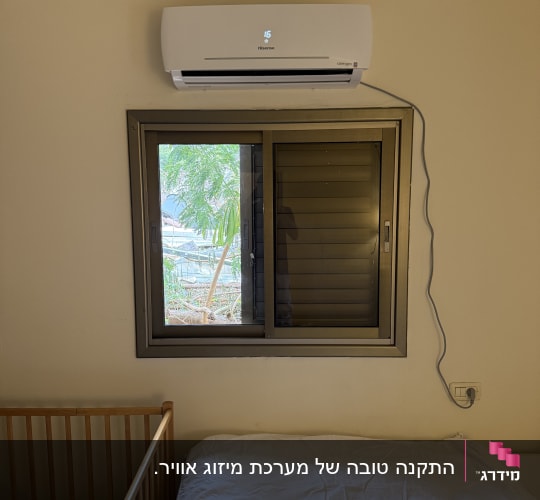 מזגן מותקן מעל חלון בחדר שינה